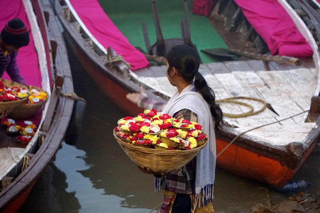 Mädchen mit Blumenkorb am Ganges
